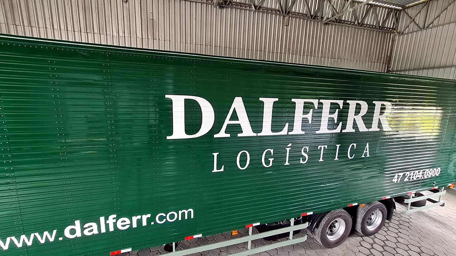 Carreta baú verde da Dalferr Logística com letreiro serifado branco, site e telefone